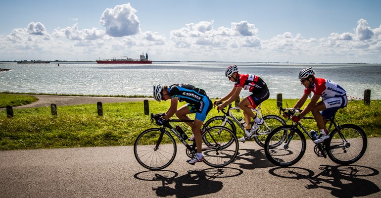 Wielrenners in de Zeeuwse natuur. Wielrennen in Zeeland is heel divers en bied wielrenners fantastische routes en mooie omgevingen.